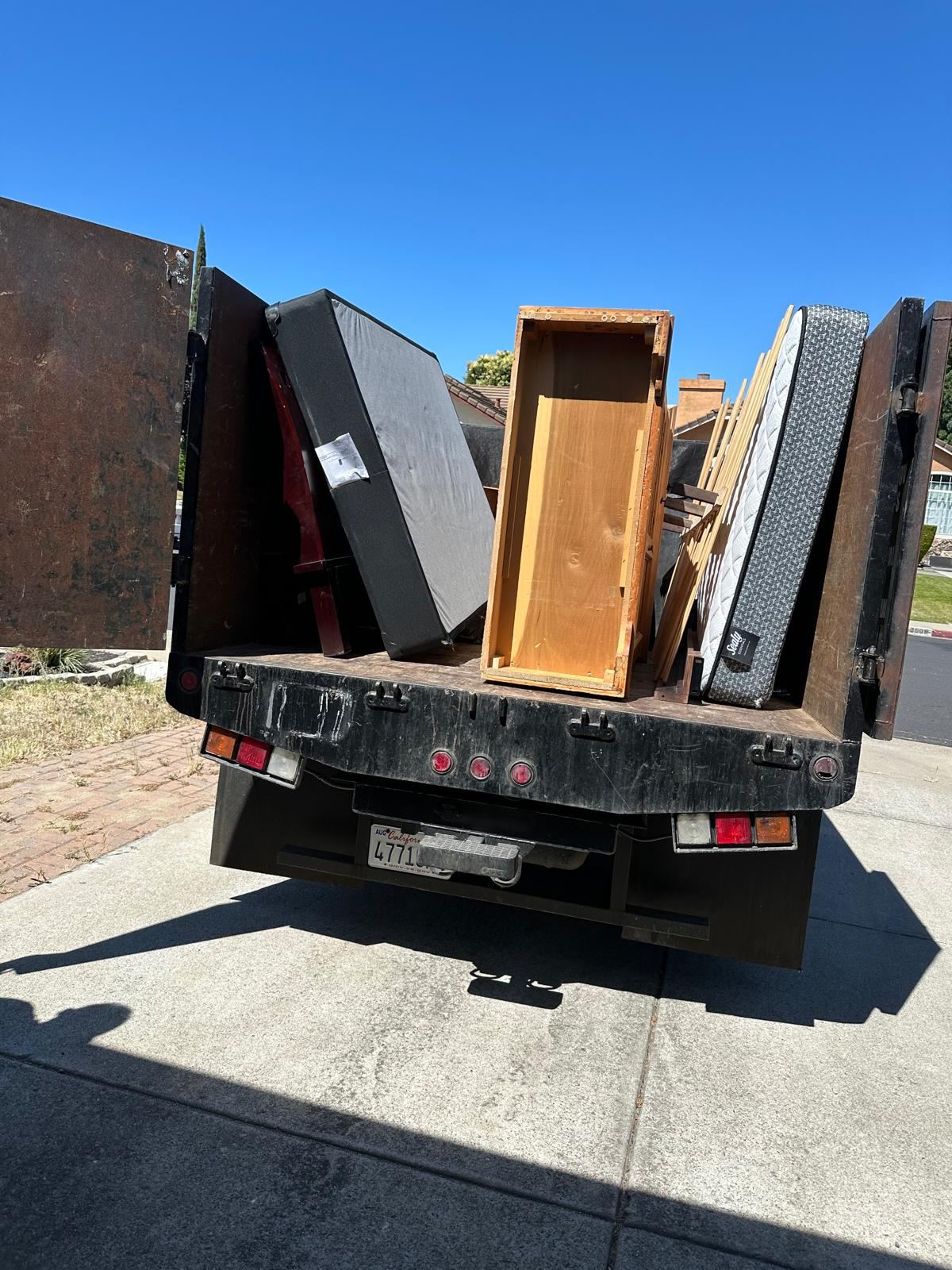 Divas junk removal truck carrying unwanted furniture and mattresses | Divas Junk Removal Services Divas junk removal truck carrying unwanted furniture and mattresses