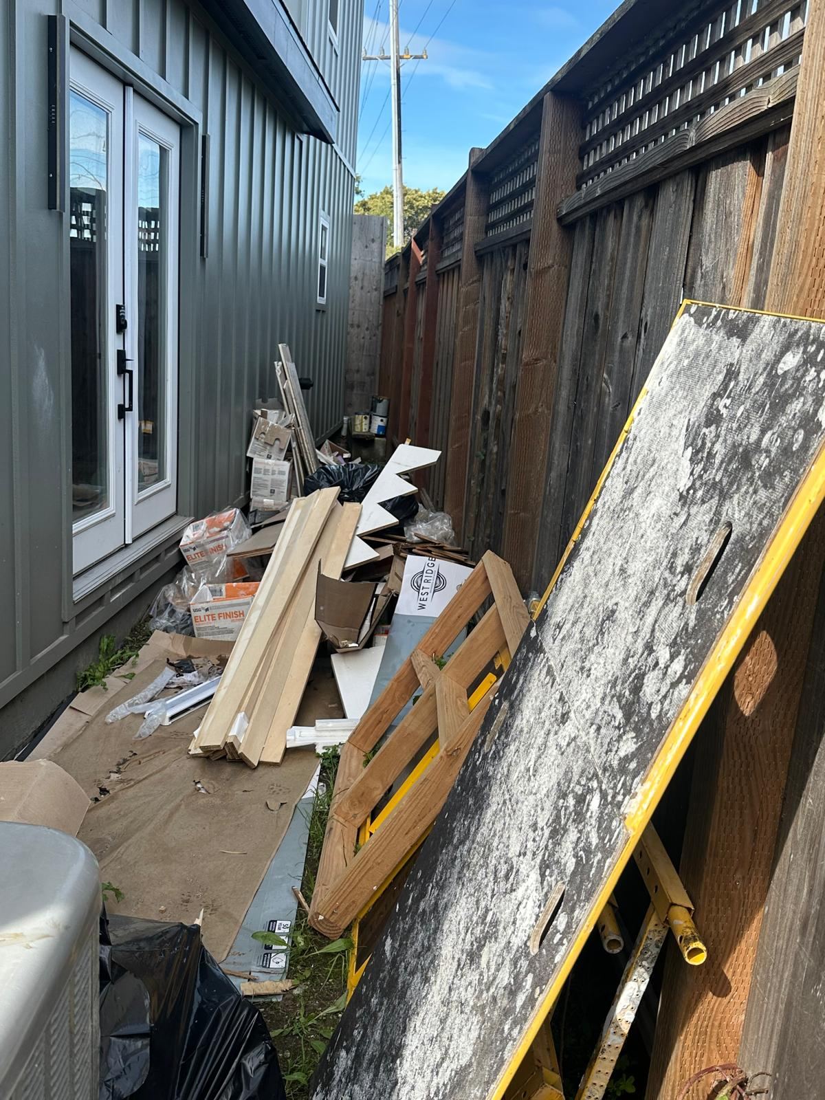 Building material scraps and clutter alongside a property | Divas Junk Removal Services Building material scraps and clutter alongside a property